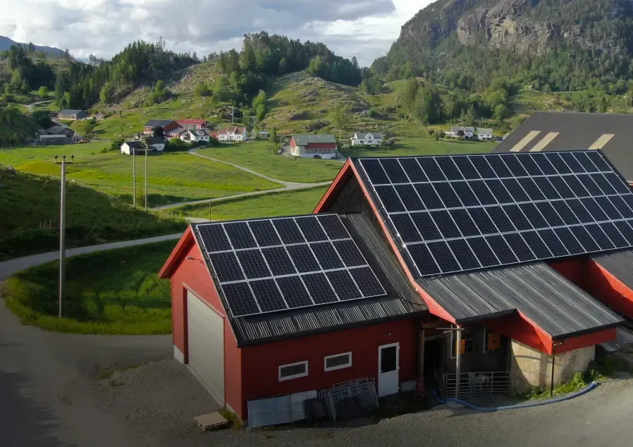 Barn with solar panels on the roof in a farming landscape