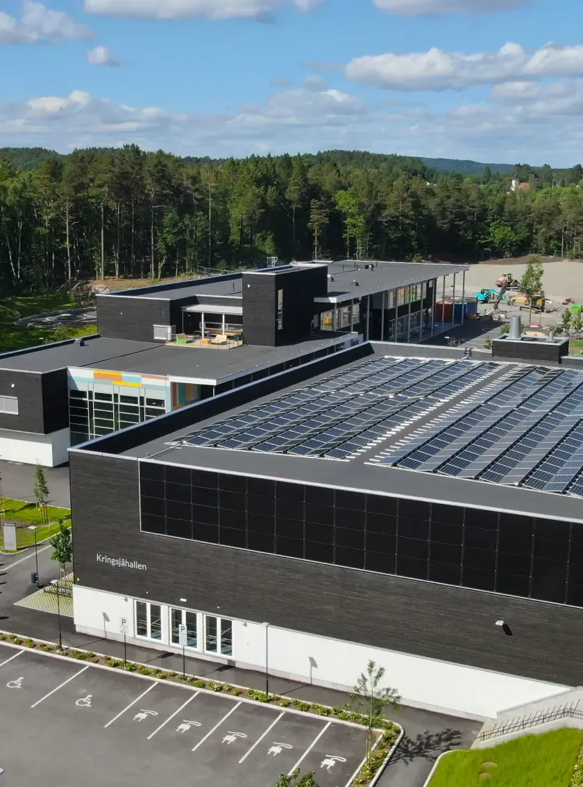 Flyfoto av Kringsjå skole i Kristiansand med solcellepaneler på taket
