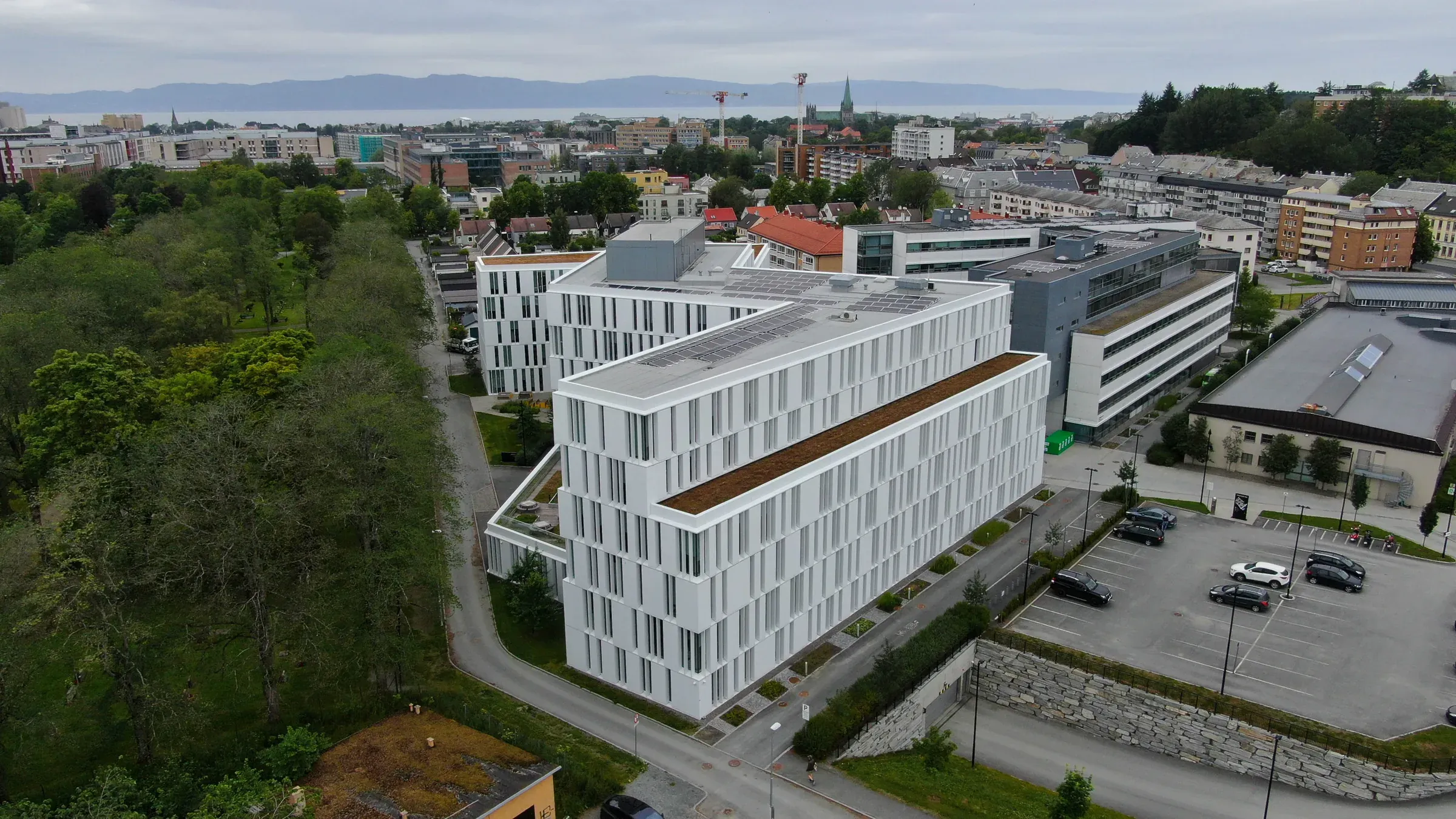 Flyfoto av det store hvite næringsbygget i Abels gate 9 i Trondheim, med solcellepaneler på taket